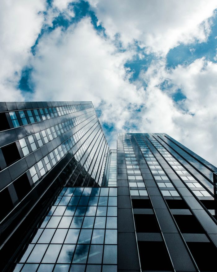 Modern skyscraper reflecting the sky in Rotterdam, showcasing urban architecture.
